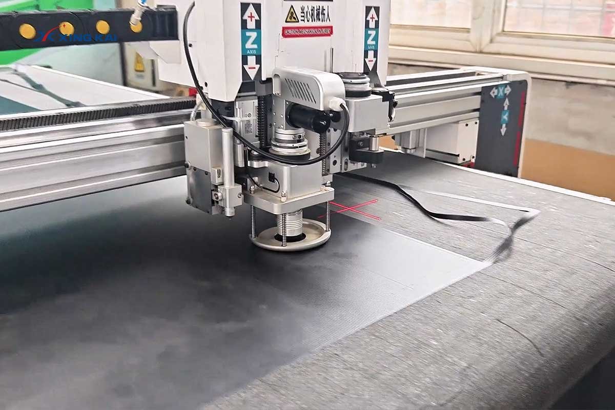 Oscillating knife tool cutting a carbon fiber material sheet on a CNC table