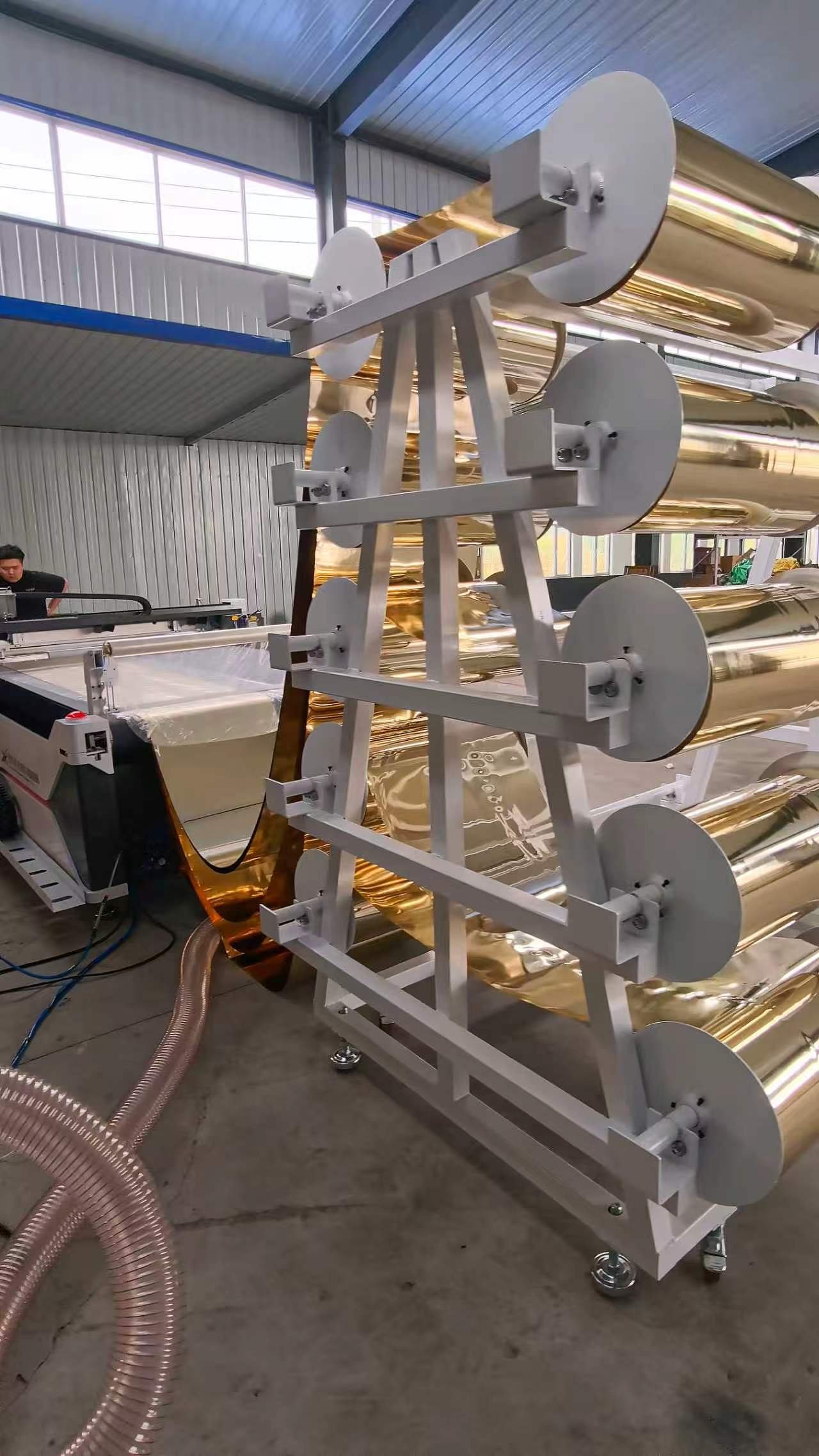 Rack holding rolls of gold reflective material for wedding decor production