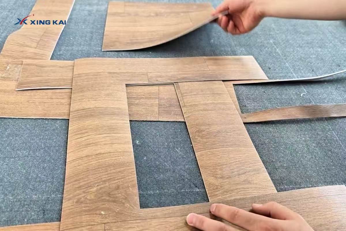Custom cut wood grain vinyl flooring pieces arranged for fitting